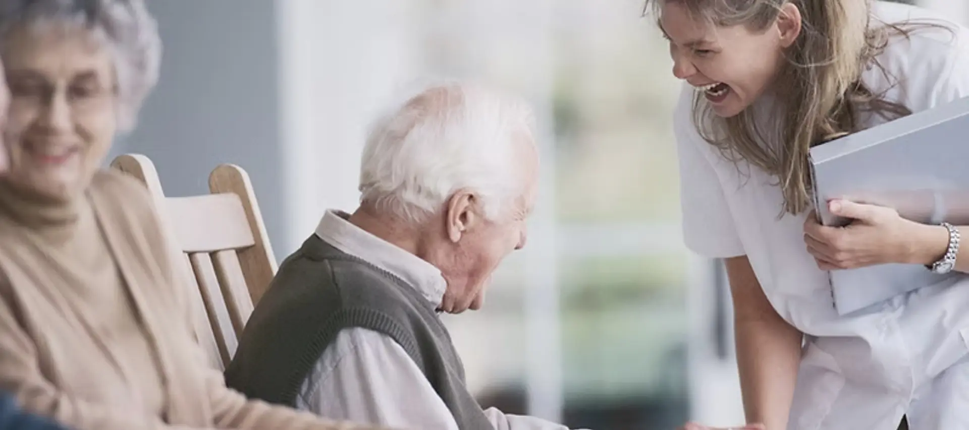Friendly caregiver helping senior woman prepare food in a well-lit kitchen