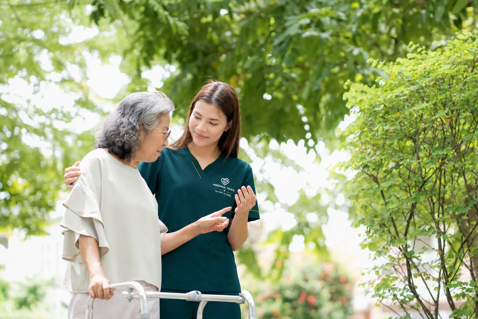 Caregiver supporting senior walking outdoors